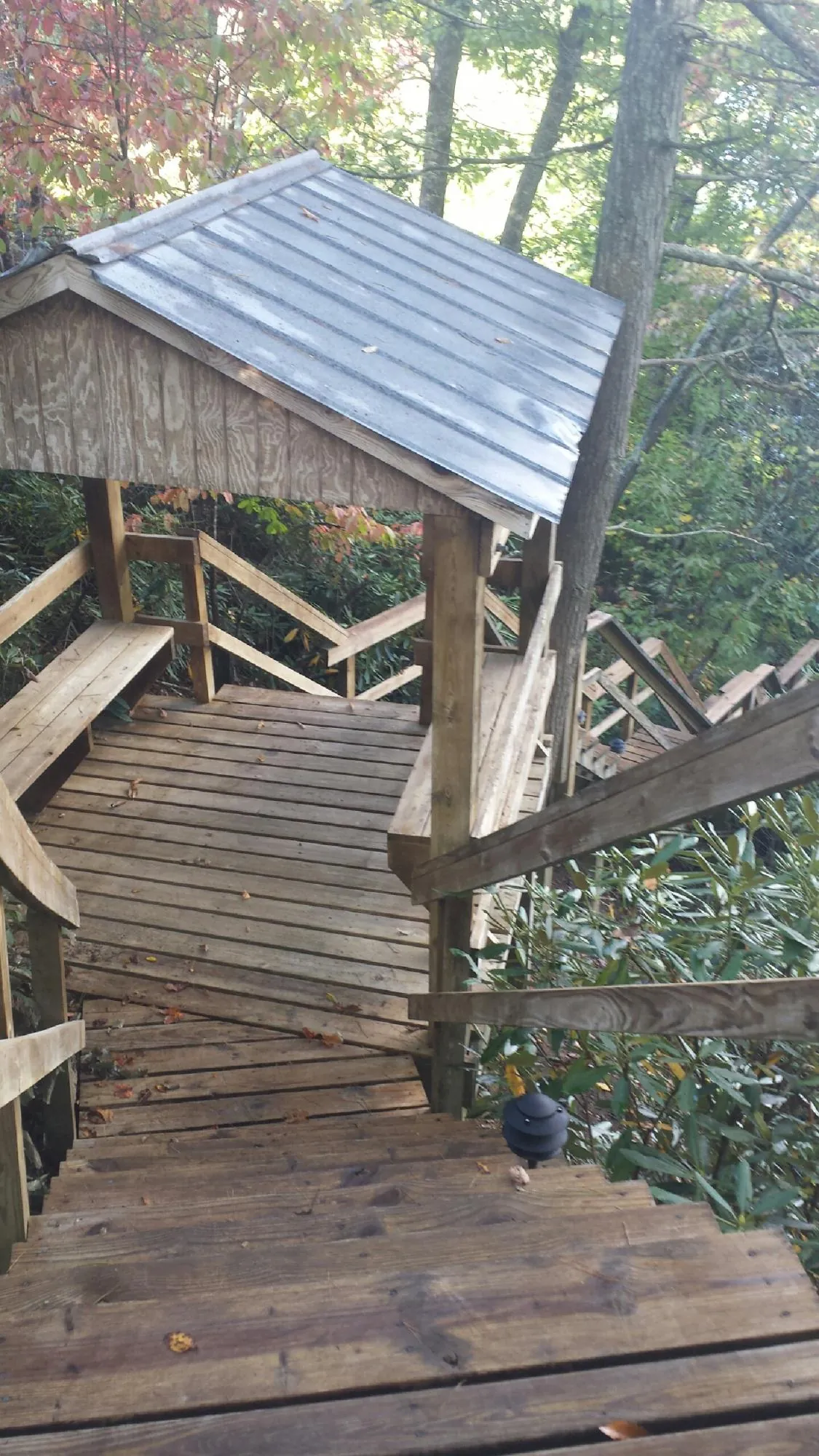 Metal roofed shelter over wooden steps on a wooded walkway — Skylight Repair & Installation work by our crew in Royalston
